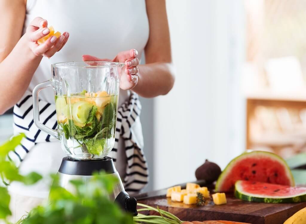 woman blending water and fruit XBCU